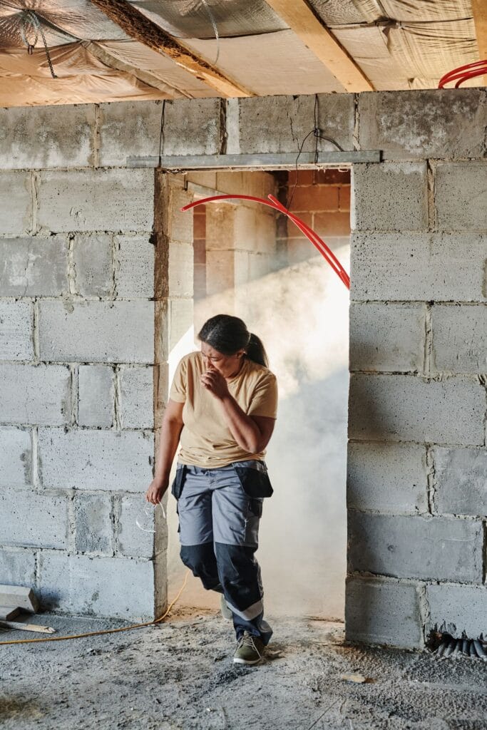 Illustrative library photograph, not an Elbaz project: a worker in a doorway cut through a block wall during a strip-out