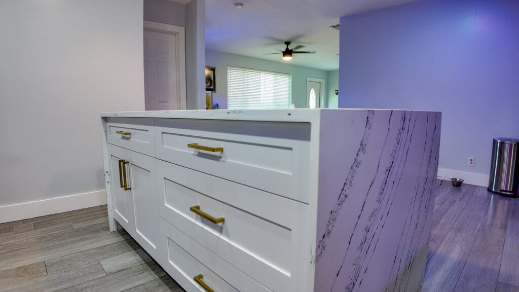 Navy shaker kitchen with brass hardware and quartz waterfall island — view 5