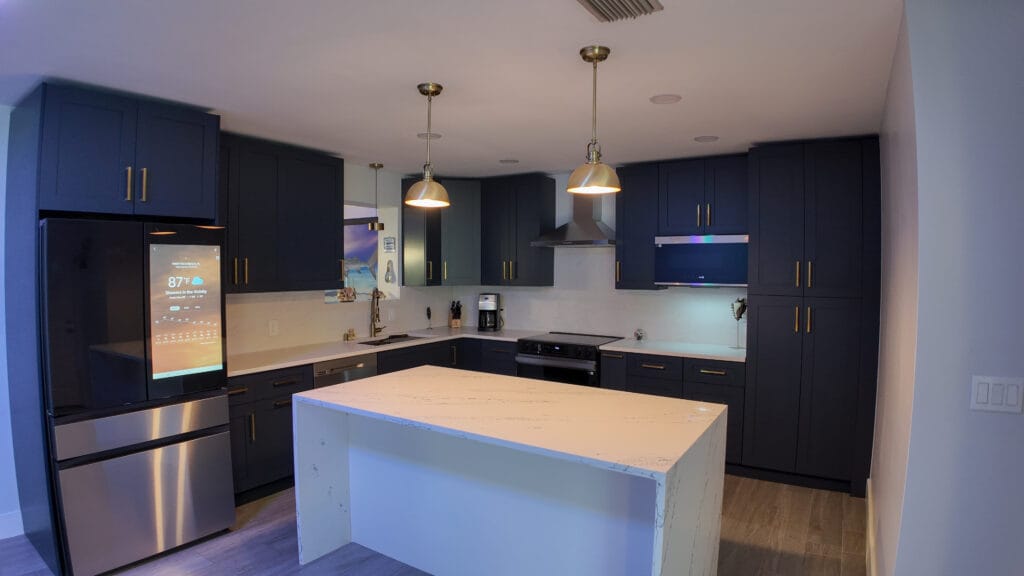 Navy shaker kitchen with brass hardware and quartz waterfall island — view 8