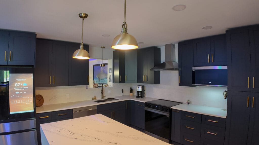 Navy shaker kitchen with brass hardware and quartz waterfall island — view 9
