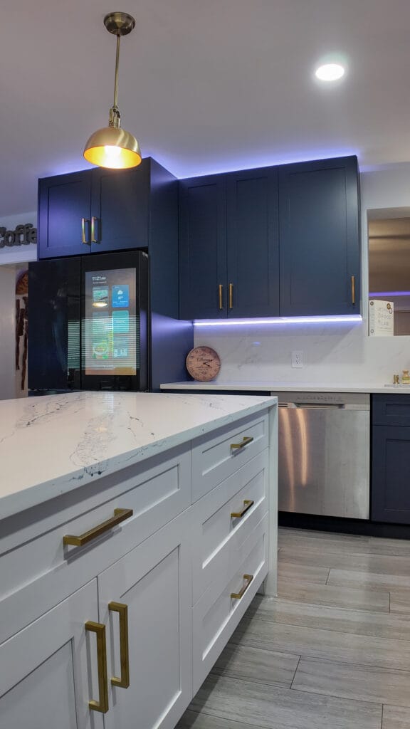 Navy shaker kitchen with brass hardware and quartz waterfall island — view 17