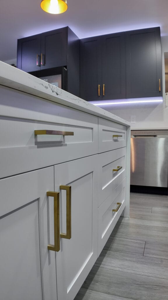 Navy shaker kitchen with brass hardware and quartz waterfall island — view 18