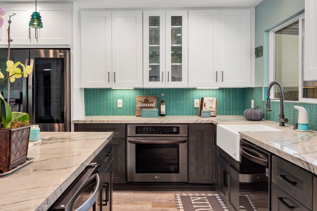 Two-tone kitchen with teal herringbone backsplash and marble waterfall island — view 6