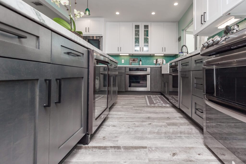 Two-tone kitchen with teal herringbone backsplash and marble waterfall island — view 14