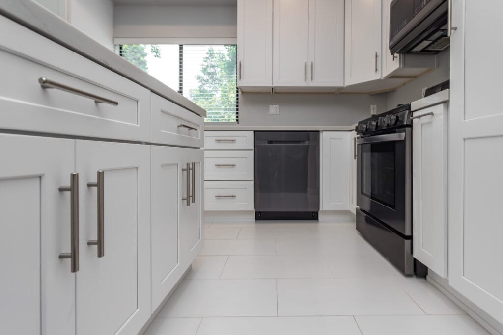 White shaker kitchen with quartz waterfall island and brushed-nickel hardware — view 4
