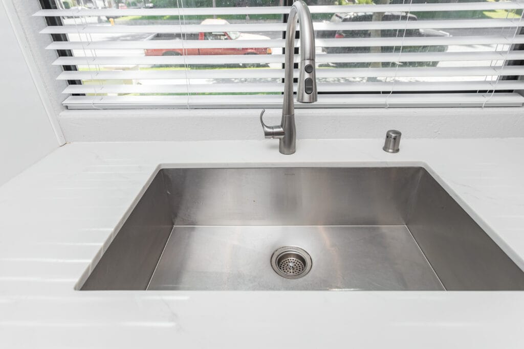 White shaker kitchen with quartz waterfall island and brushed-nickel hardware — view 5