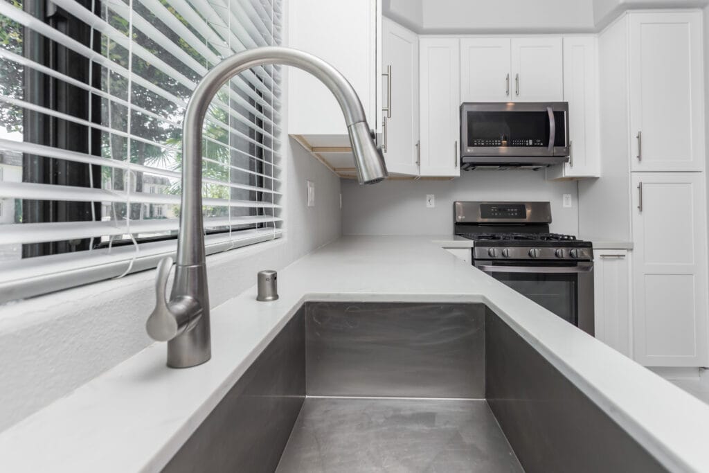 White shaker kitchen with quartz waterfall island and brushed-nickel hardware — view 6