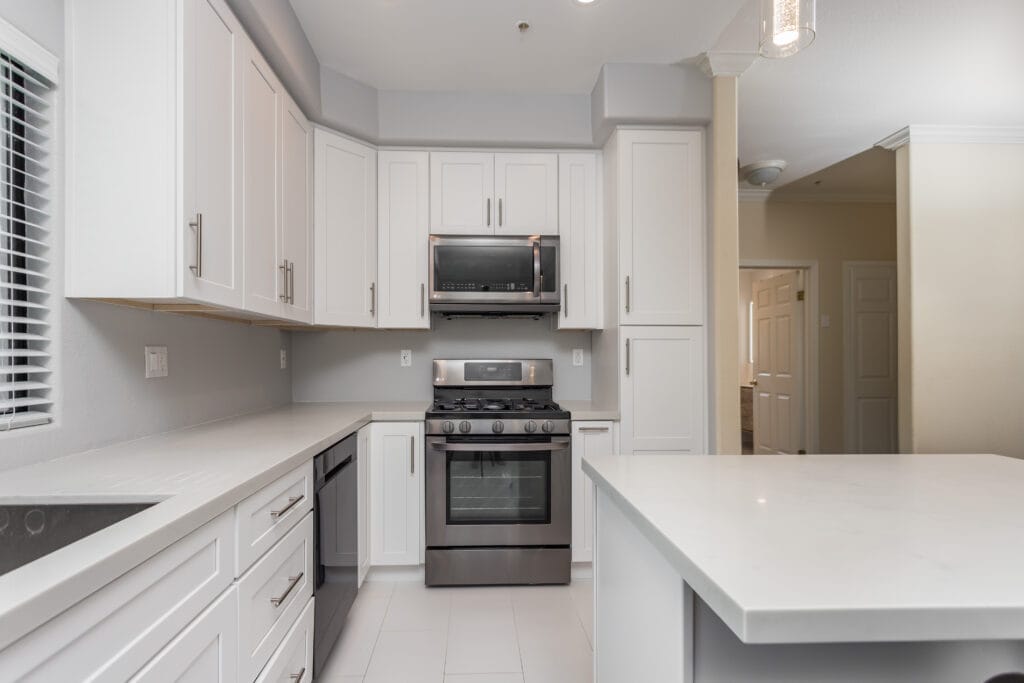 White shaker kitchen with quartz waterfall island and brushed-nickel hardware — view 9