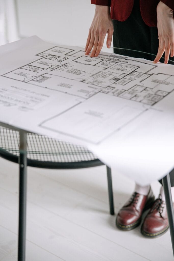 Illustrative library photograph, not an Elbaz project: a house floor plan laid out on a glass table