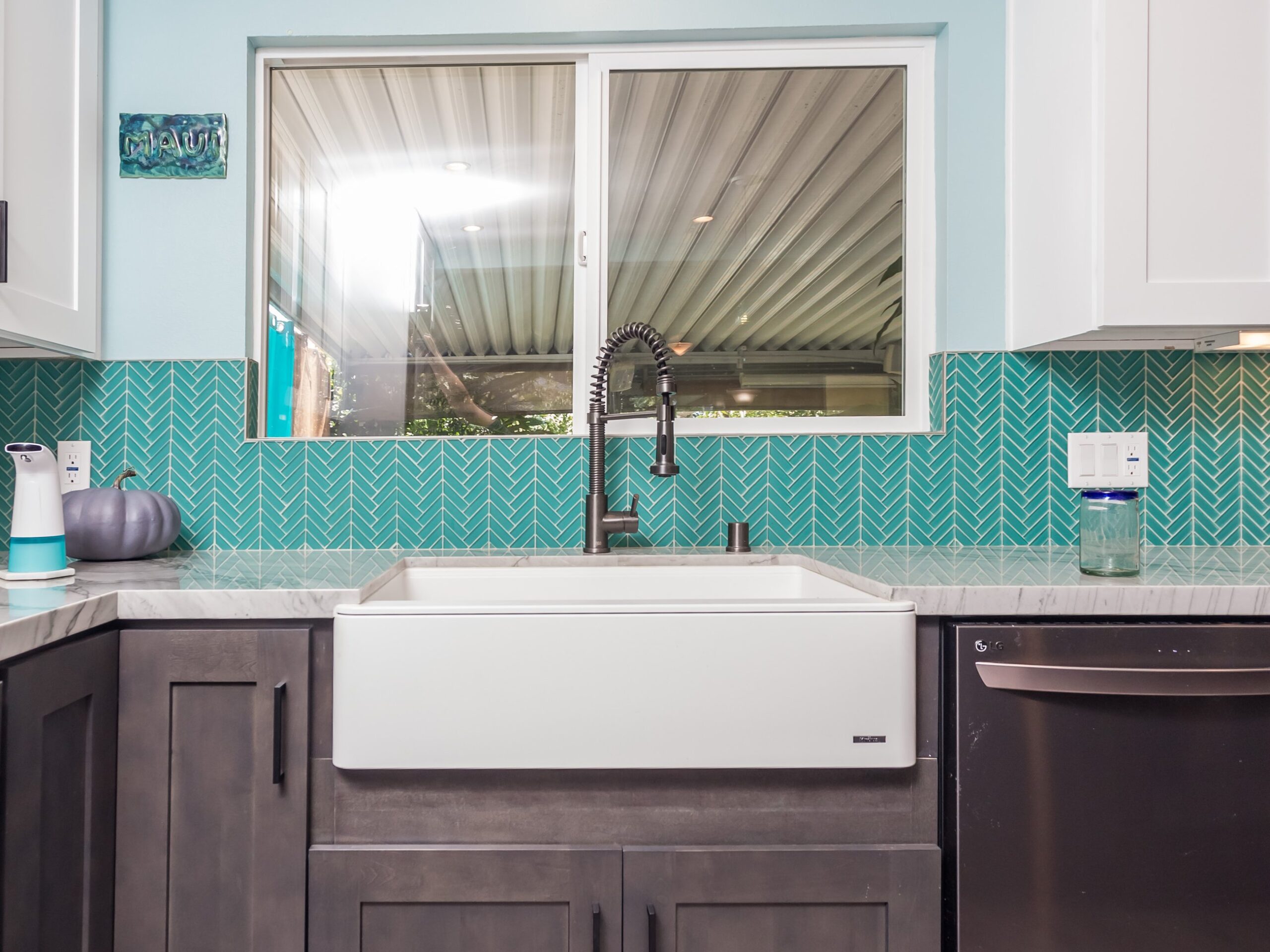 Apron-front sink set into a stained shaker base cabinet with quartz worktop either side
