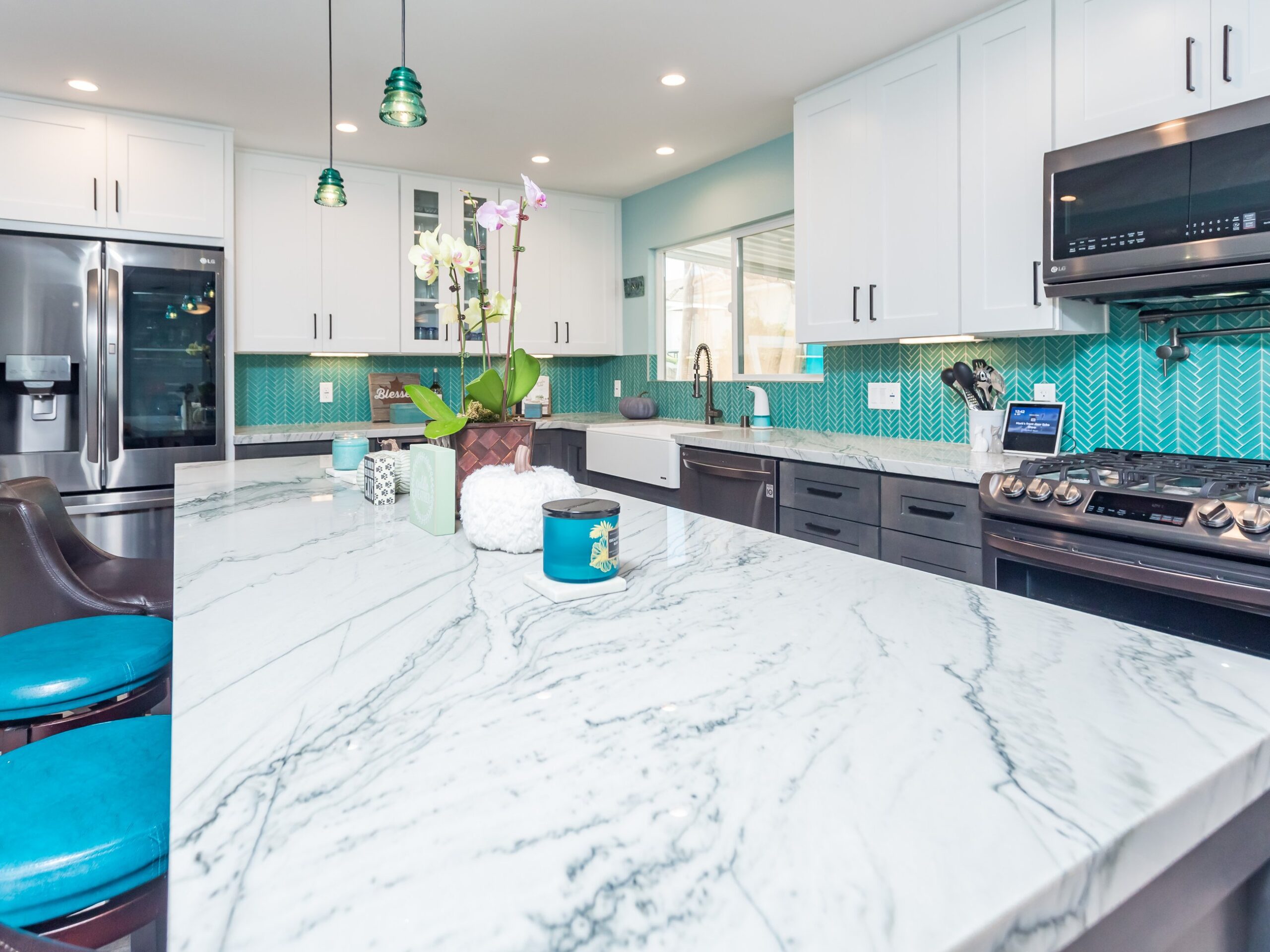 Veined quartz worktop running across painted and stained cabinetry