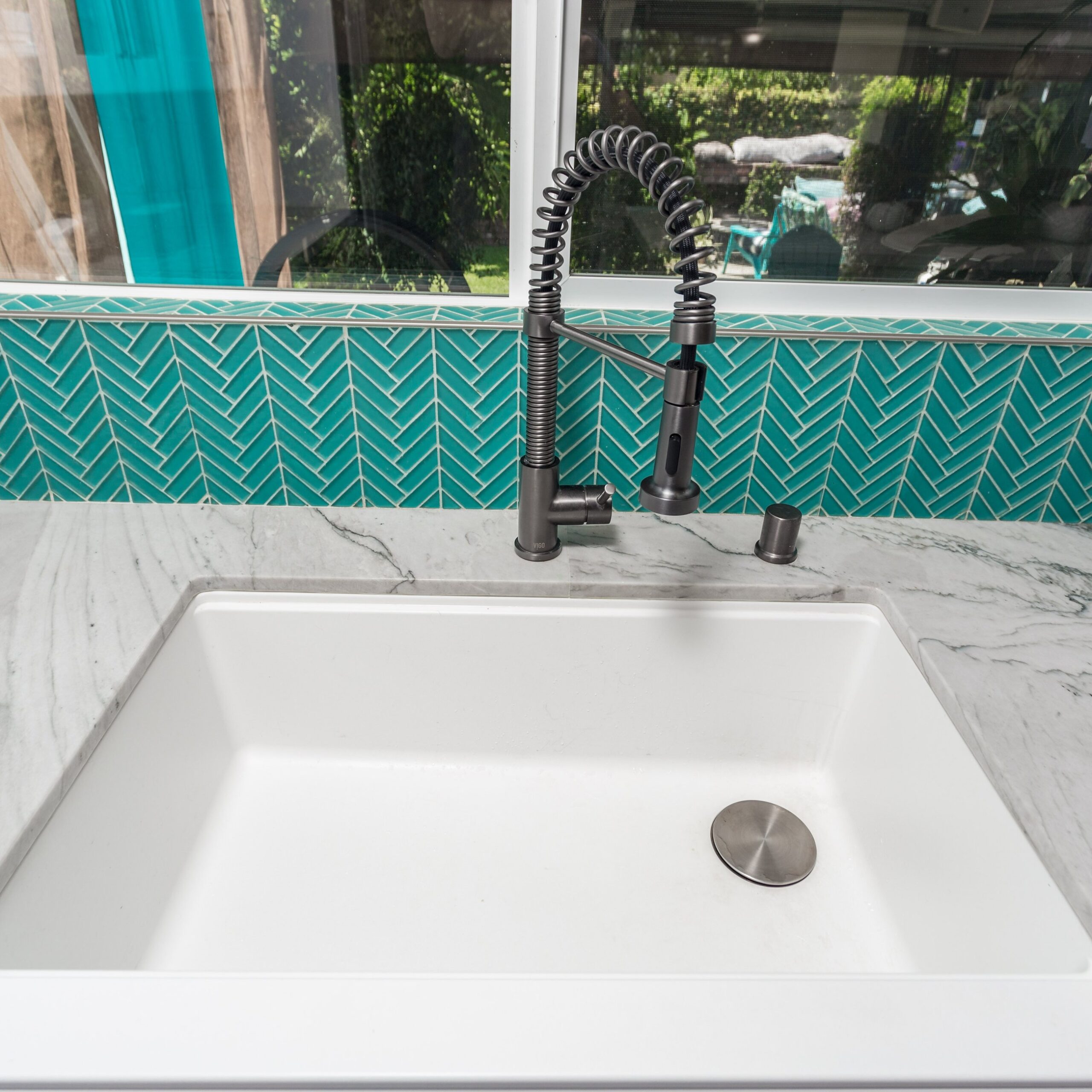Undermount sink, quartz worktop and tap where the worktop meets the backsplash