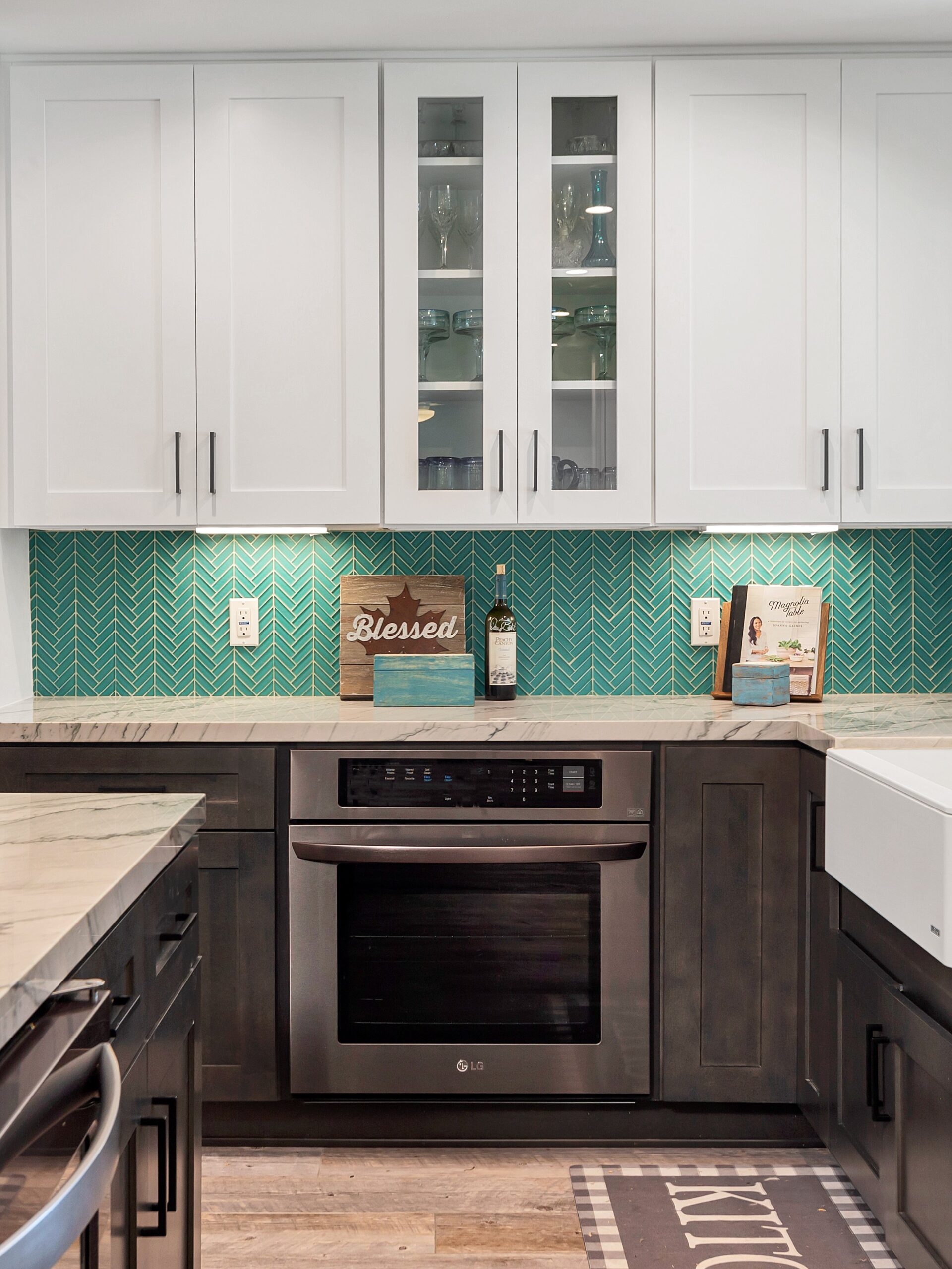 Painted upper cabinets with a glass-fronted door beside a run of solid doors