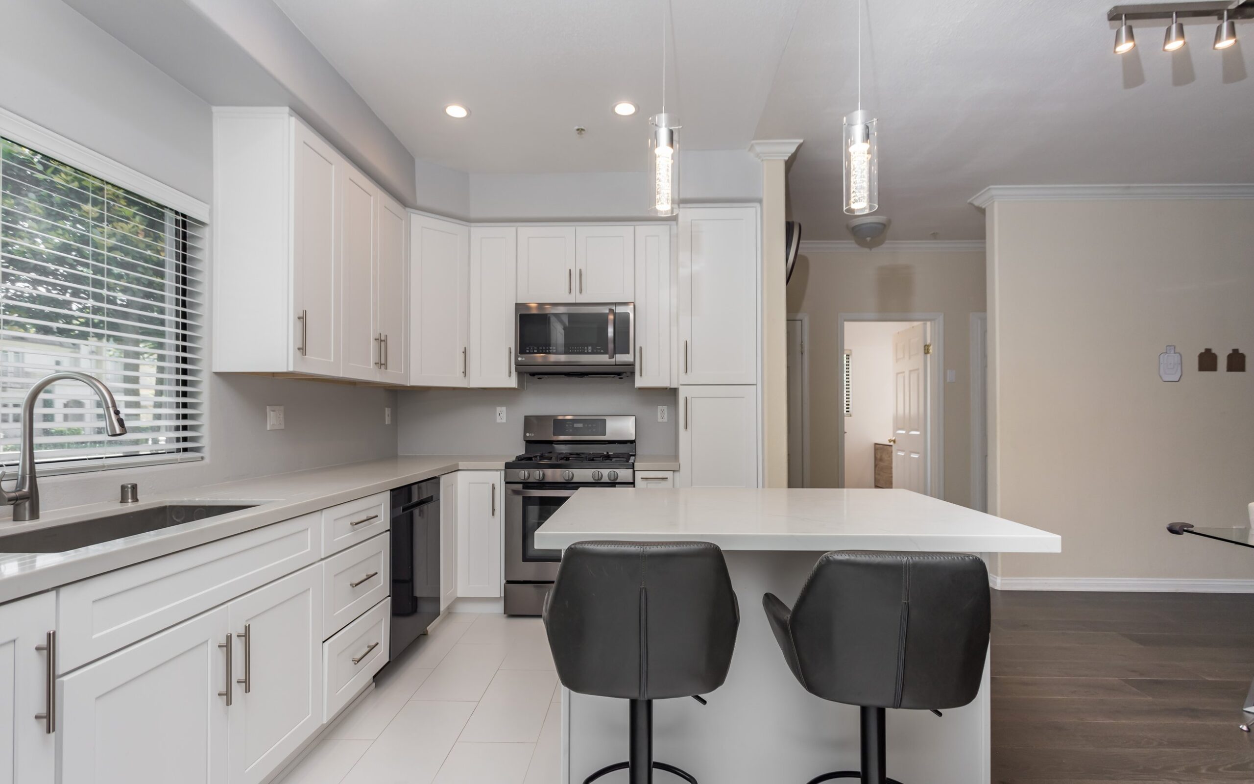 White shaker island with bar seating and a pale quartz worktop