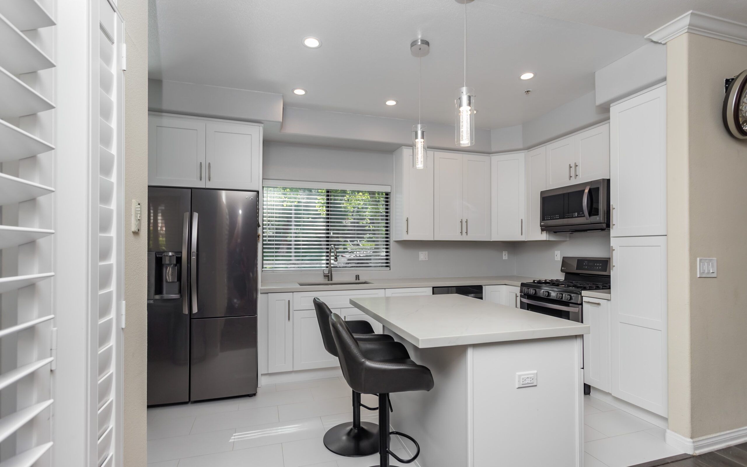 All-white shaker kitchen with quartz worktops and stainless appliances