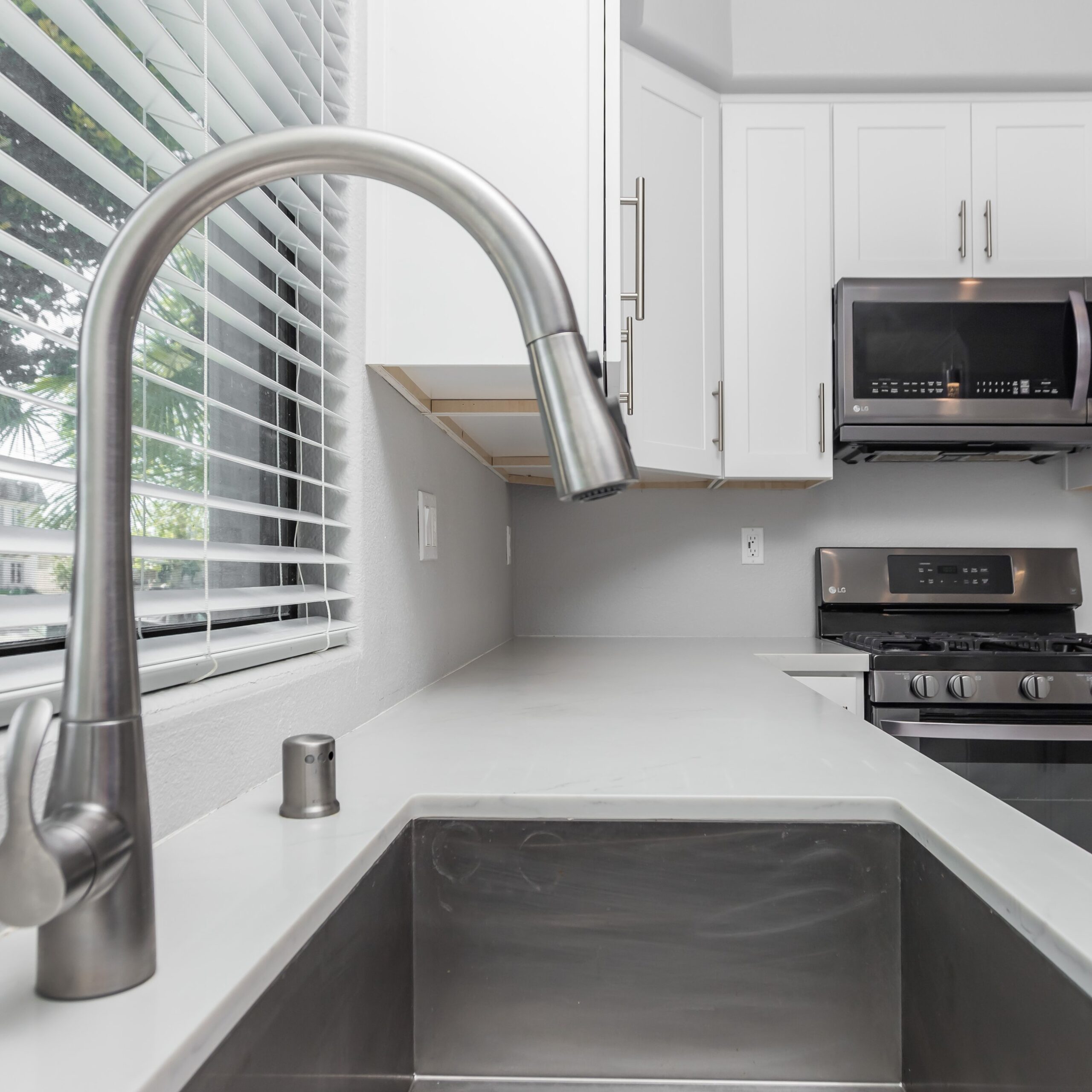 Pull-down tap over an undermount sink in a white shaker kitchen