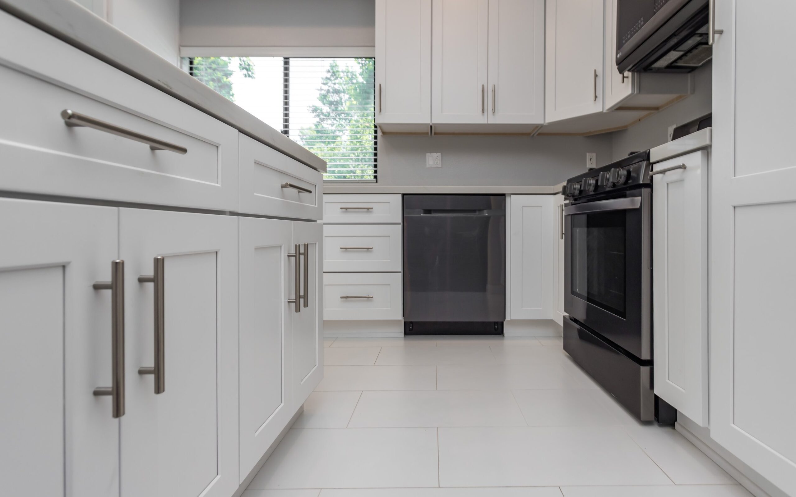 Run of white shaker base and wall cabinets with a tall unit closing the run