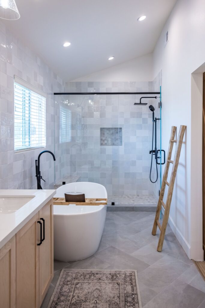 Freestanding tub with a floor-mounted filler, the glazed walk-in shower behind it