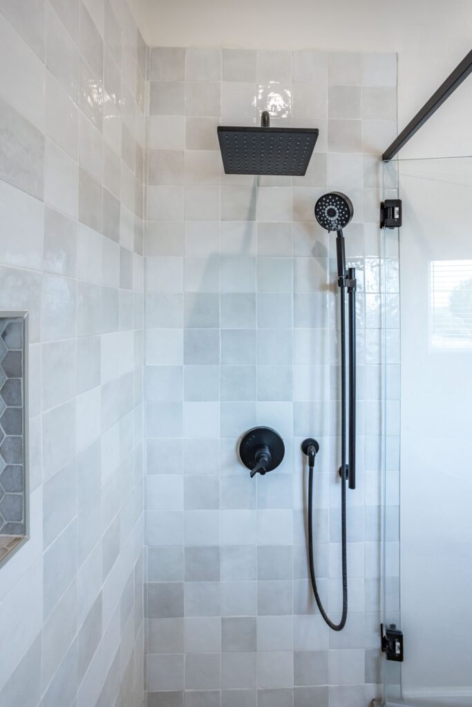 Rain head and hand shower in matte black on the tiled wet wall