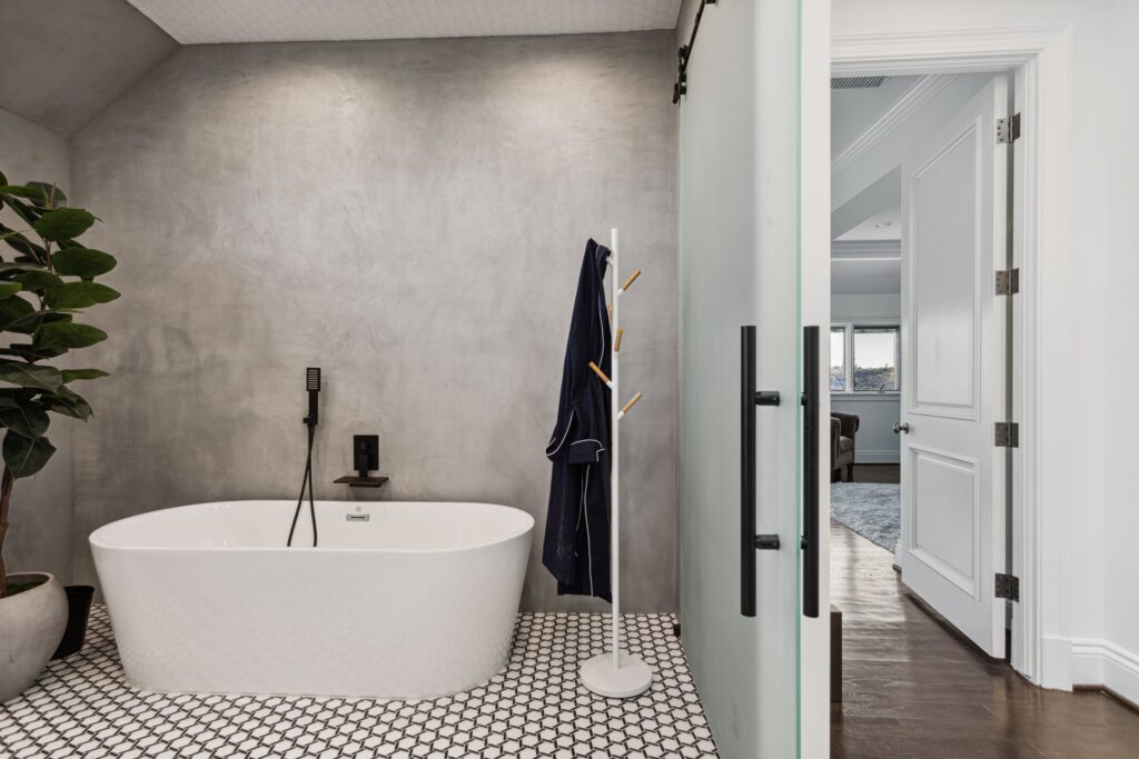The tub with the suite door open to the bedroom beyond