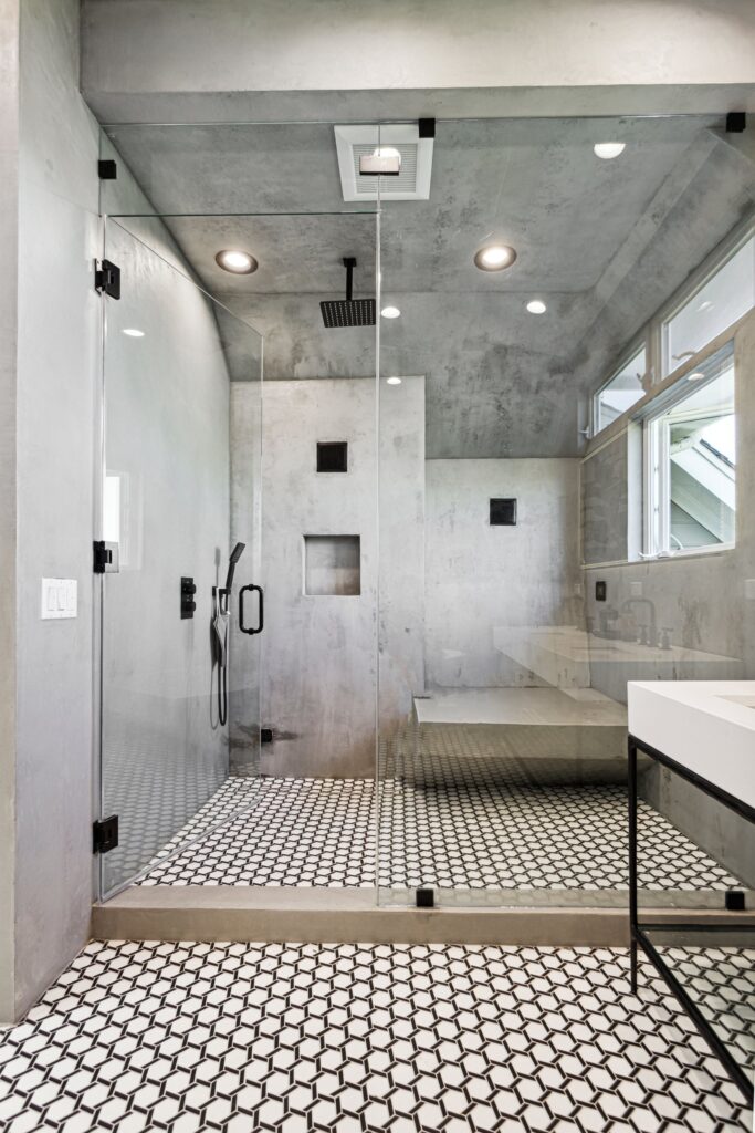 Inside the shower: rain head, bench and the mosaic running through