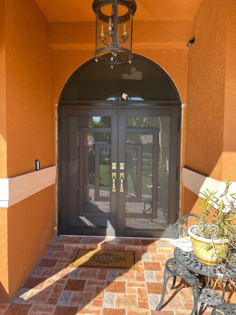 Elbaz installation: impact entry doors in an arched opening, seen from the porch
