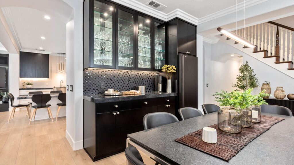 Open-plan kitchen with a quartzite island and black cabinetry, completed by Elbaz Construction in South Florida