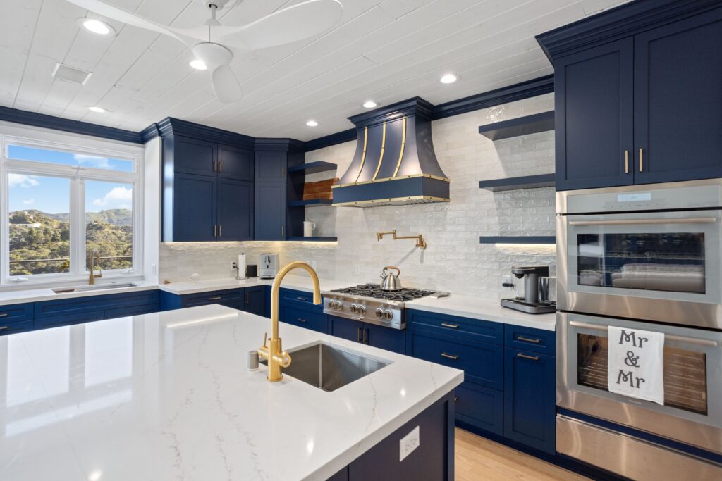 Island and range wall with the custom hood and brass pot filler above the range