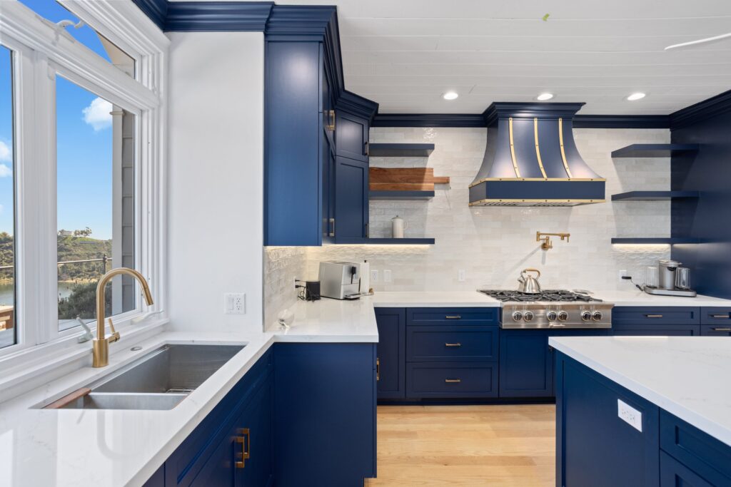 Sink run beneath the window with brass tapware and stacked splashback