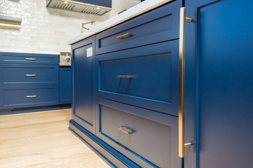 Close view of the shaker door and drawer fronts on the island, with brass pulls