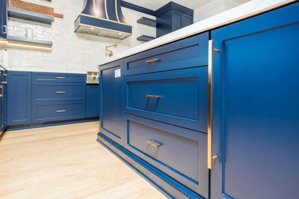Drawer fronts and brass bar pulls on the island end
