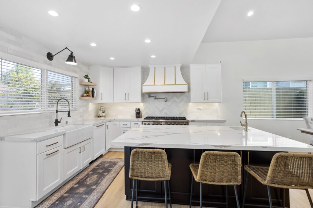Island with woven counter stools and a marble-look worktop
