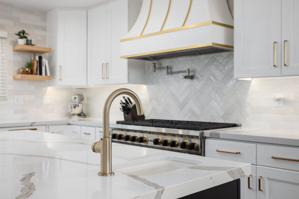 Open timber shelving beside the hood and brass tapware at the prep sink