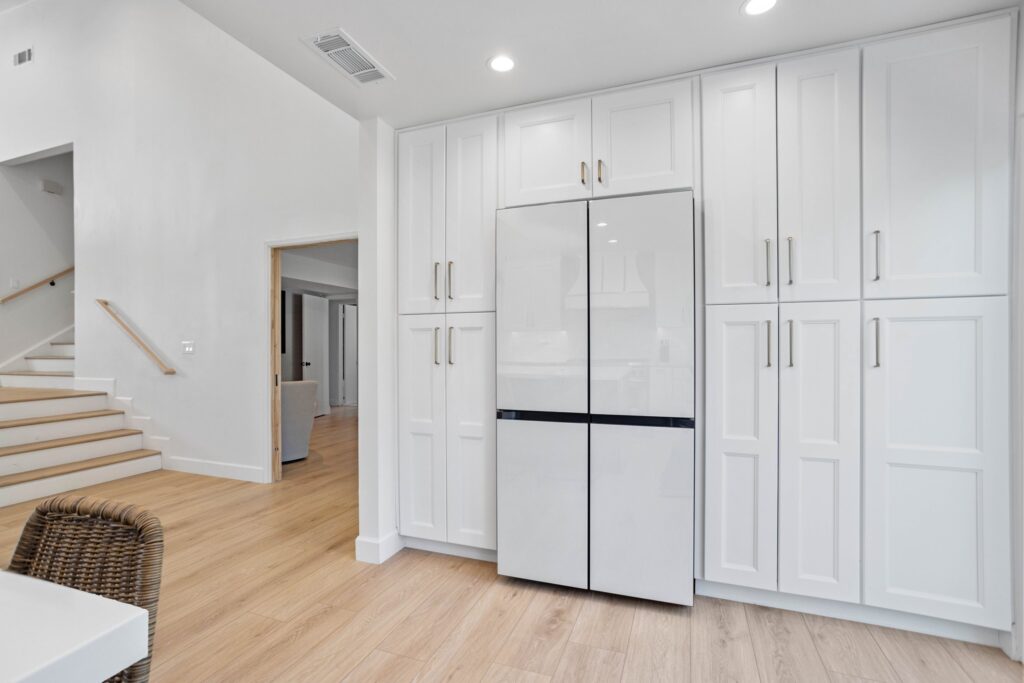 Full-height pantry and refrigeration bank in white shaker