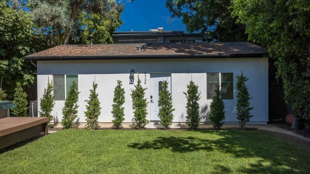 Completed guest house seen across a rear lawn, converted by Elbaz Construction in South Florida