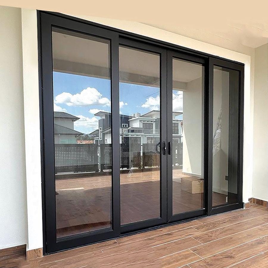 Dark-framed multi-slide impact door standing open onto a tiled terrace