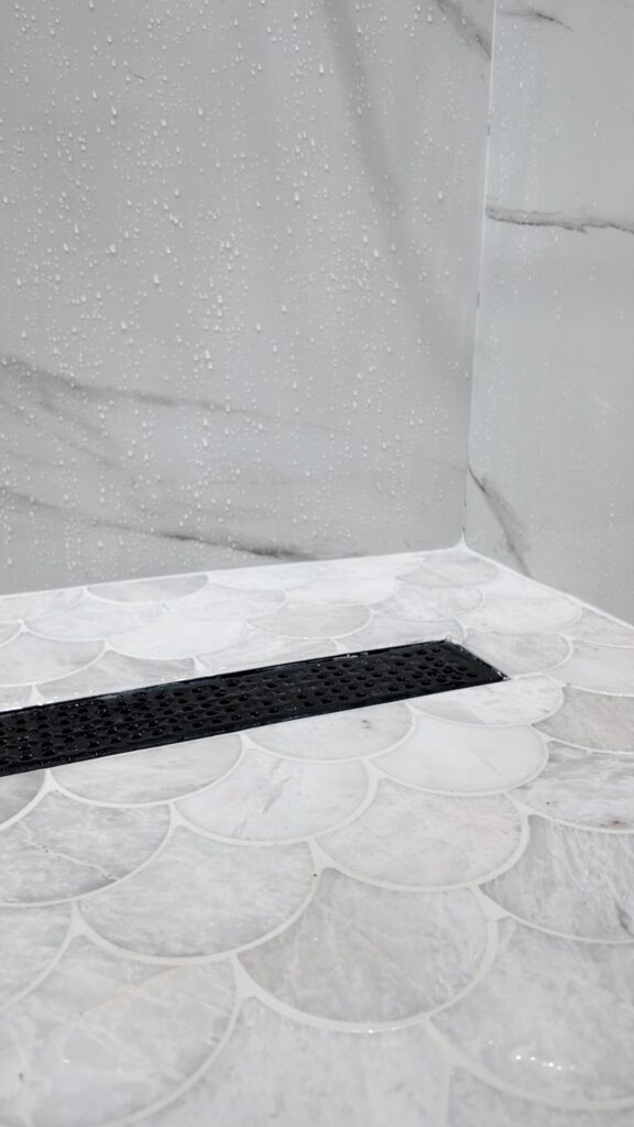 Level shower entry with a linear drain set flush at the threshold