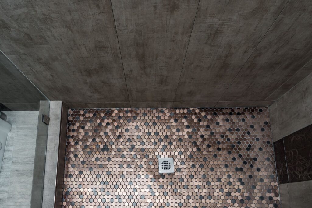 Shower floor falling to a centre drain, with no curb at the entry