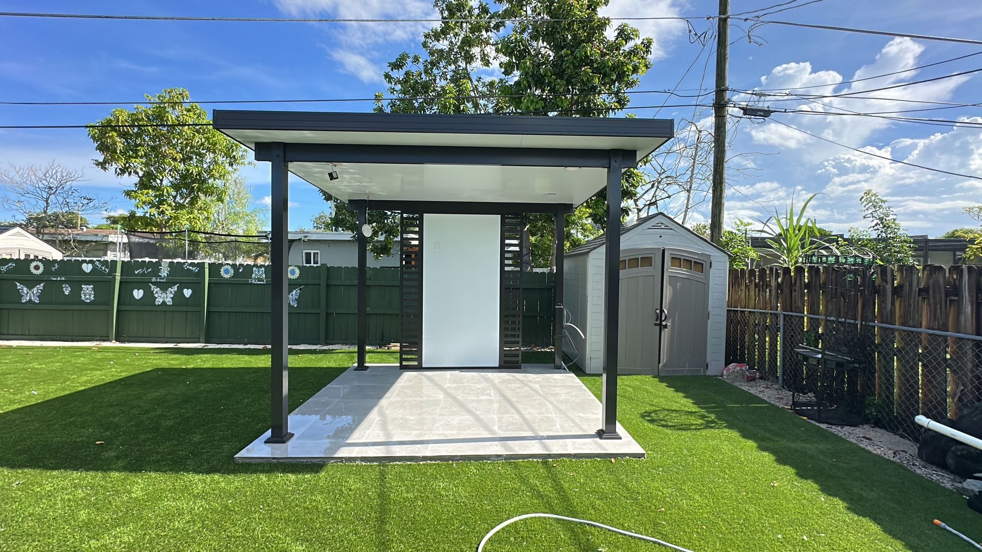 Freestanding pavilion over a paved plinth on artificial turf, complete