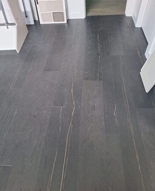 Dark-stained wide-plank flooring in a finished interior