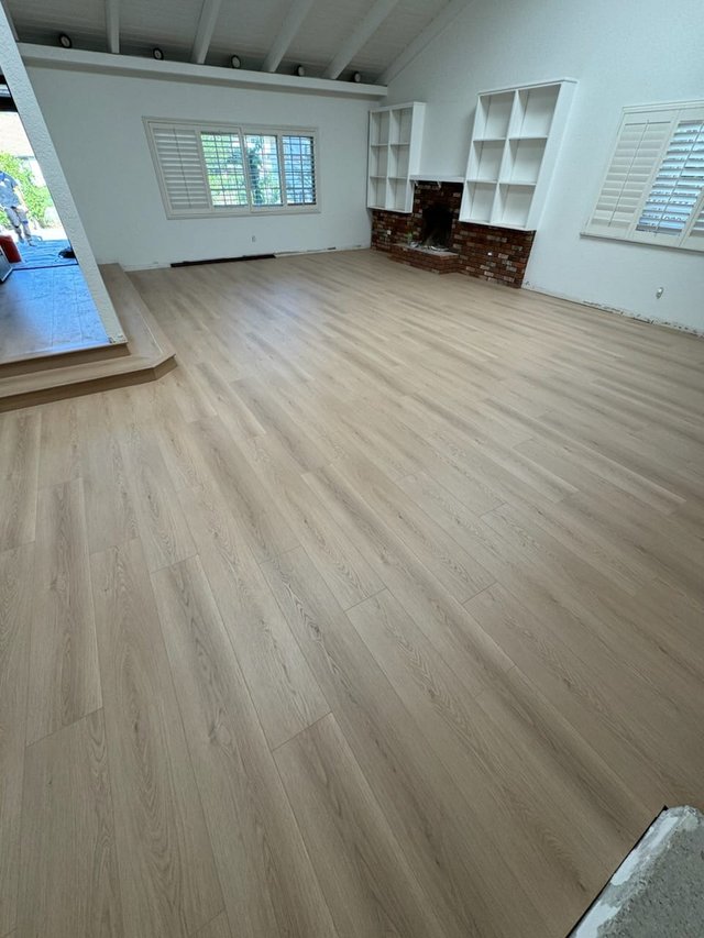 Light plank flooring meeting white skirting in a finished room