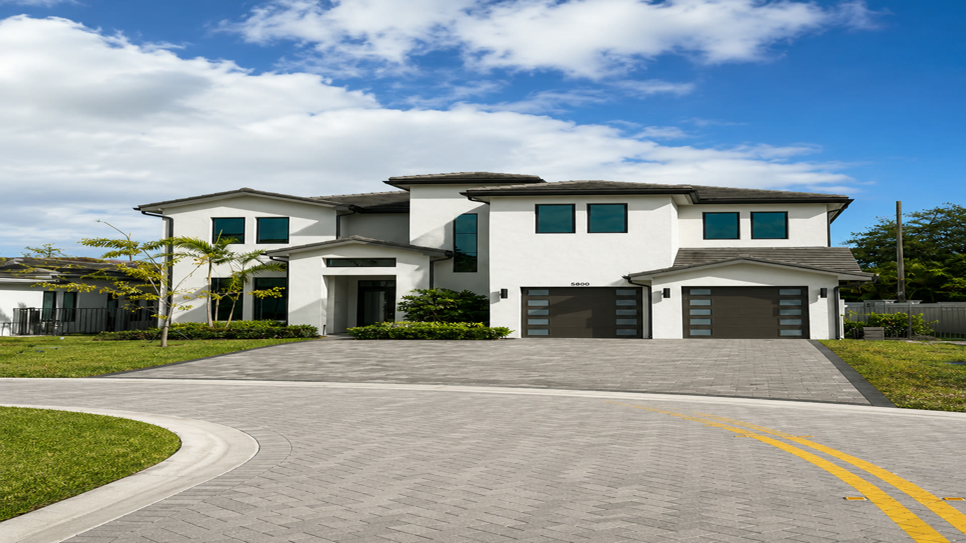 Completed Elbaz Construction paver driveway: interlocking concrete pavers laid to a South Florida home with a soldier-course border