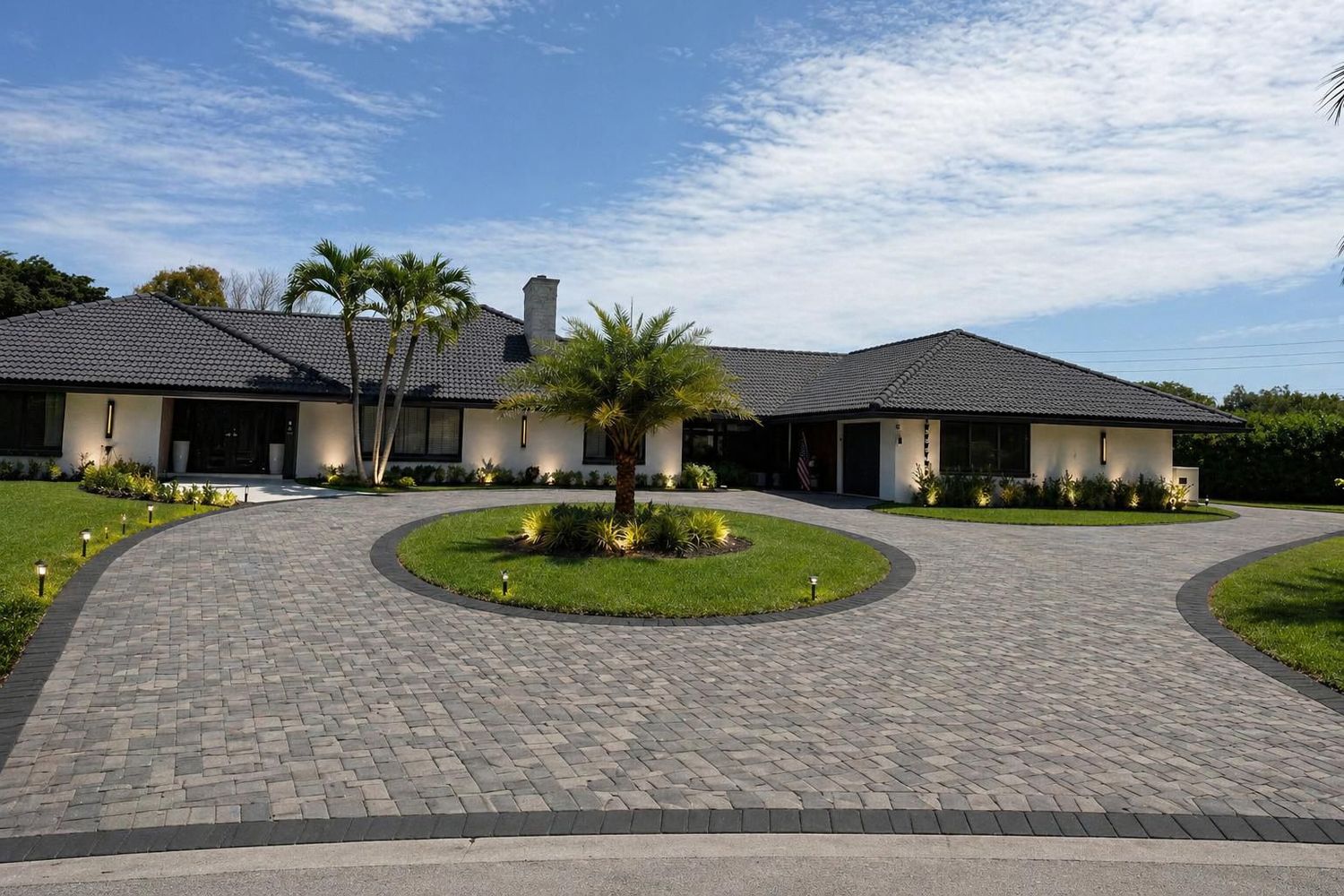 Circular paver driveway around a planted island at a single-storey home