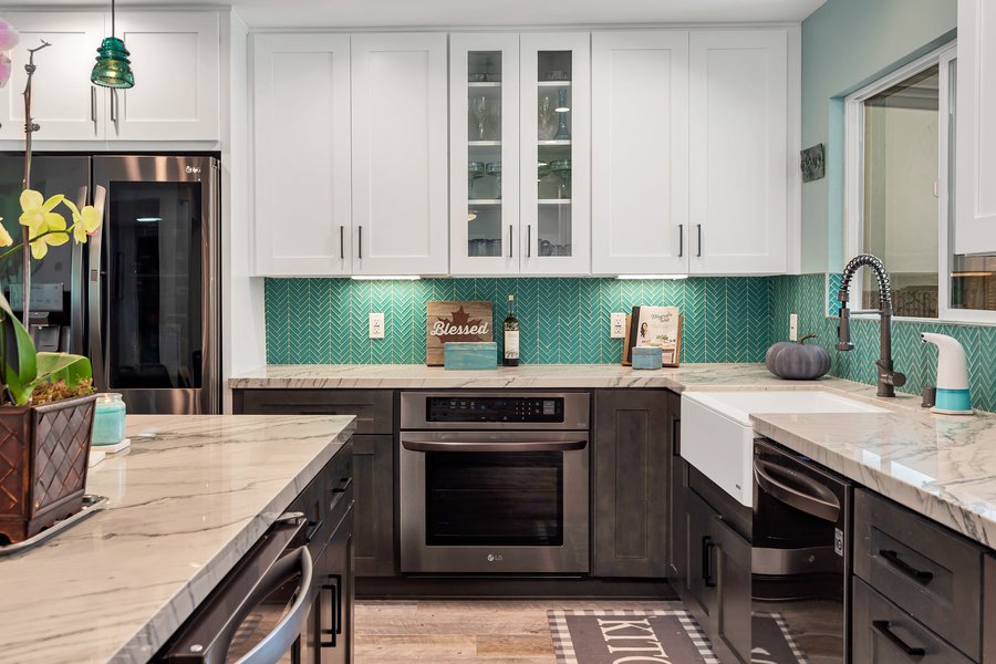 Run of dark shaker cabinetry with a farmhouse sink and stone worktop in a completed kitchen