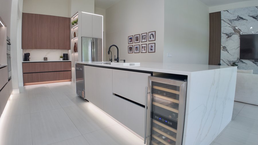 End of a kitchen island with a wine refrigerator built into the cabinet run beneath the worktop