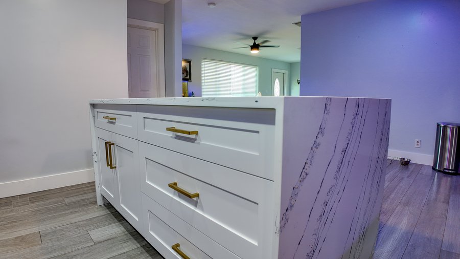 Waterfall end of a kitchen island, with the stone mitred at the corner and the veining carried down the side