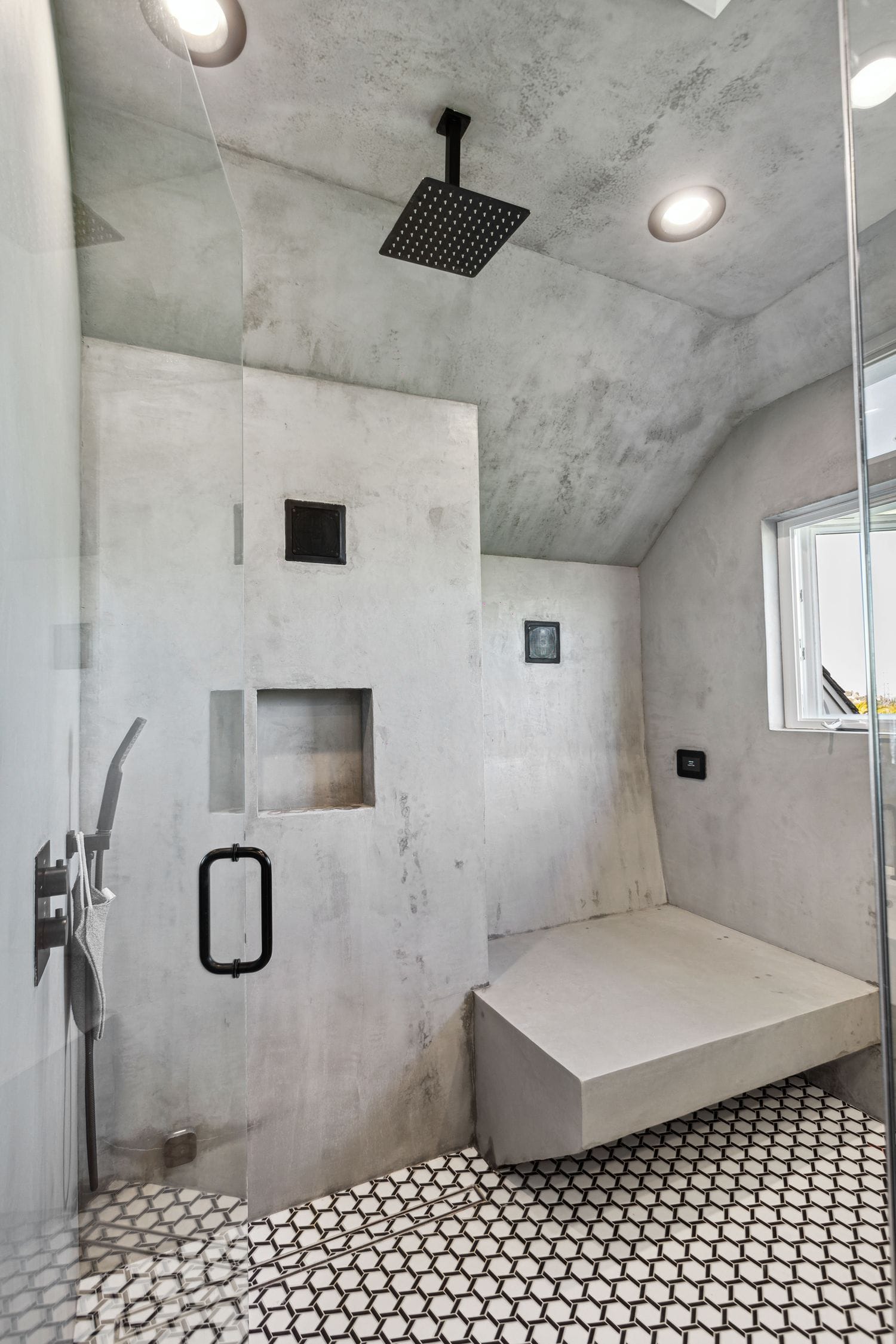 Curbless walk-in shower with a floating bench in a micro-cement finish