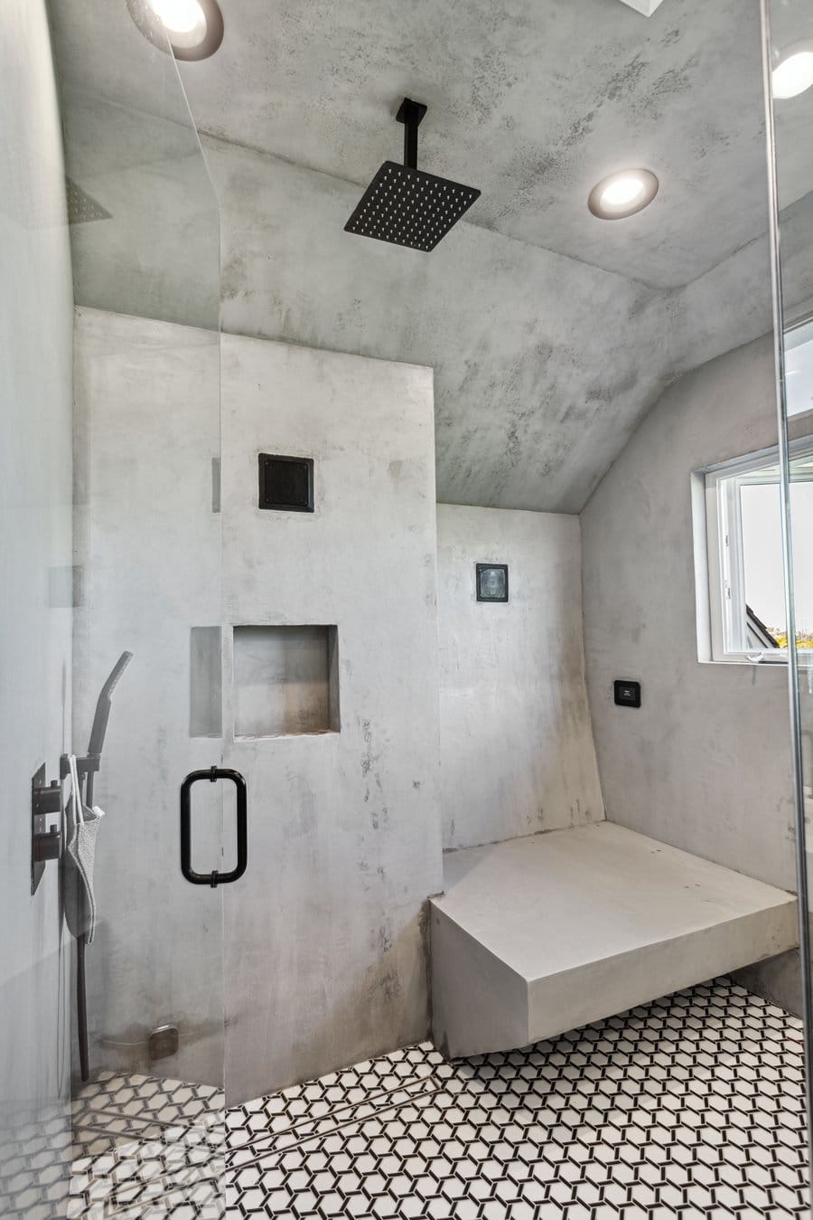 Curbless walk-in shower with a floating bench in a micro-cement finish