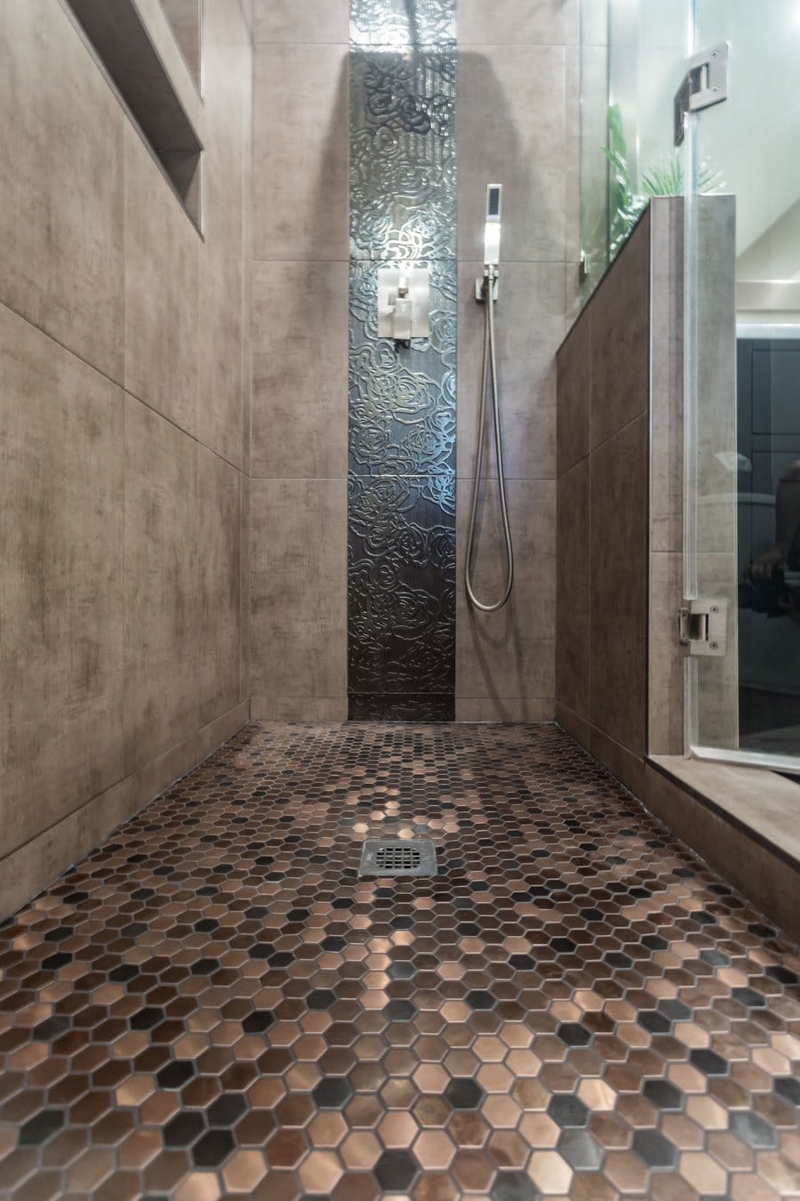 Copper-toned penny-round mosaic shower floor falling to a central drain