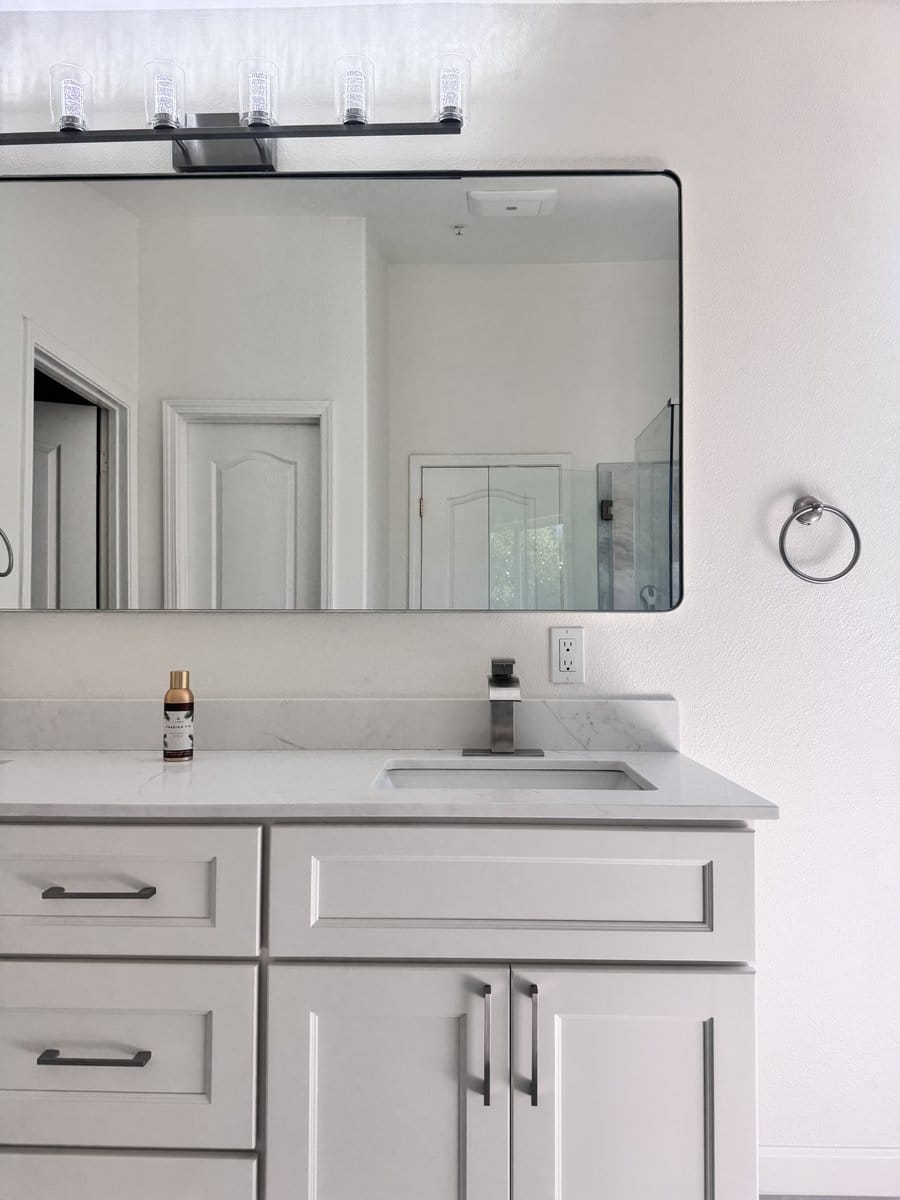 White shaker vanity with a quartz top, undermount basin and brushed nickel tap